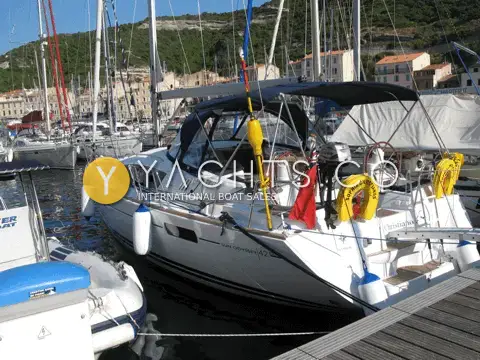 Jeanneau 42 DS: moored stern-to in a harbour below a hillside town, outboard on the pushpit