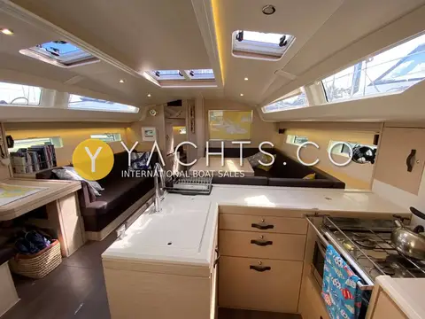 Jeanneau 51: saloon and galley with light oak joinery, dark upholstery and overhead deck hatches