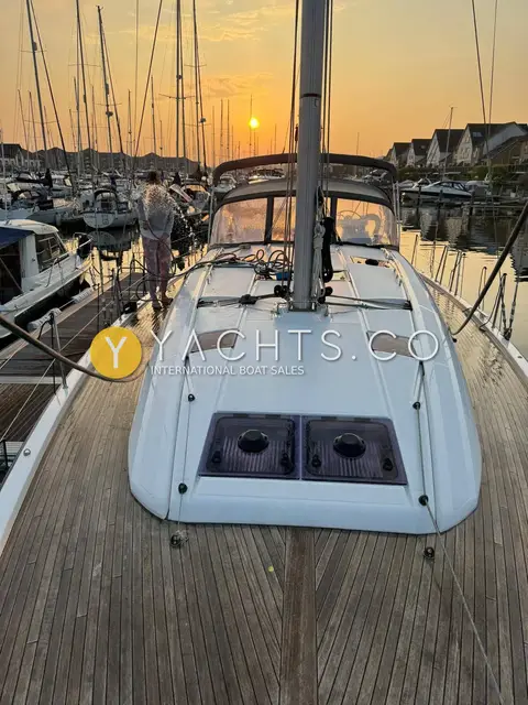 Jeanneau 51: teak foredeck and coachroof with hatches at sunset in a marina