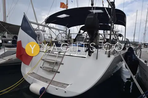 Jeanneau 57 Yacht: stern view with bathing ladder, outboard on pushpit bracket and navy bimini over twin wheels