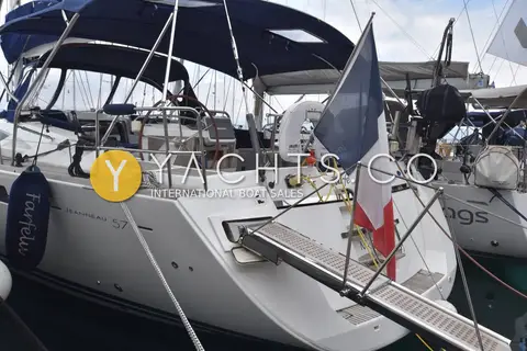 Jeanneau 57 Yacht: port quarter showing extended passerelle, Jeanneau 57 hull lettering and navy bimini