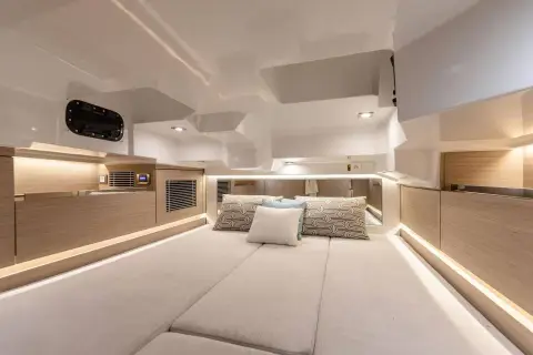 Jeanneau Cap Camarat 10.5 CC: bright cabin interior with a large double berth, light wood panelling and LED strip lighting