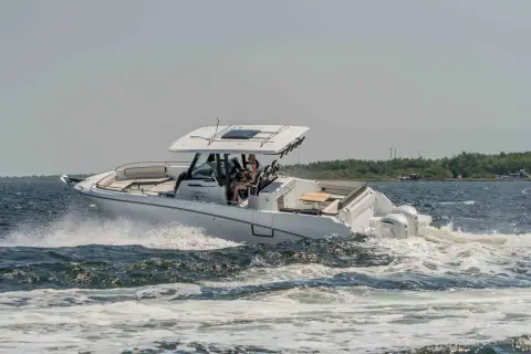 Jeanneau Cap Camarat 10.5 CC: hull running at speed through choppy water, twin outboards and T-top visible