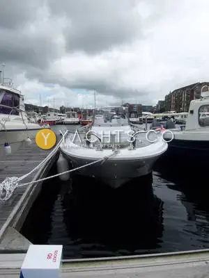 Jeanneau Cap Camarat 4.7C.C: bow view of the white open boat moored stern-to on a pontoon in a cloudy marina