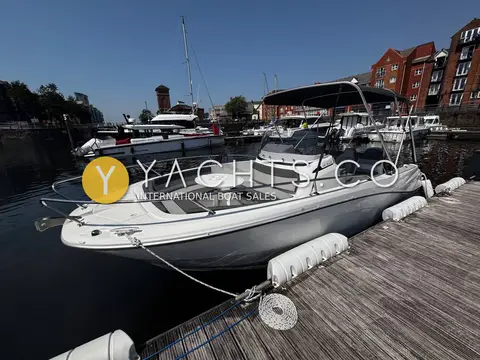 Jeanneau Cap Camarat 6.5 CC S3: bow quarter view alongside pontoon showing forward seating and bimini over console