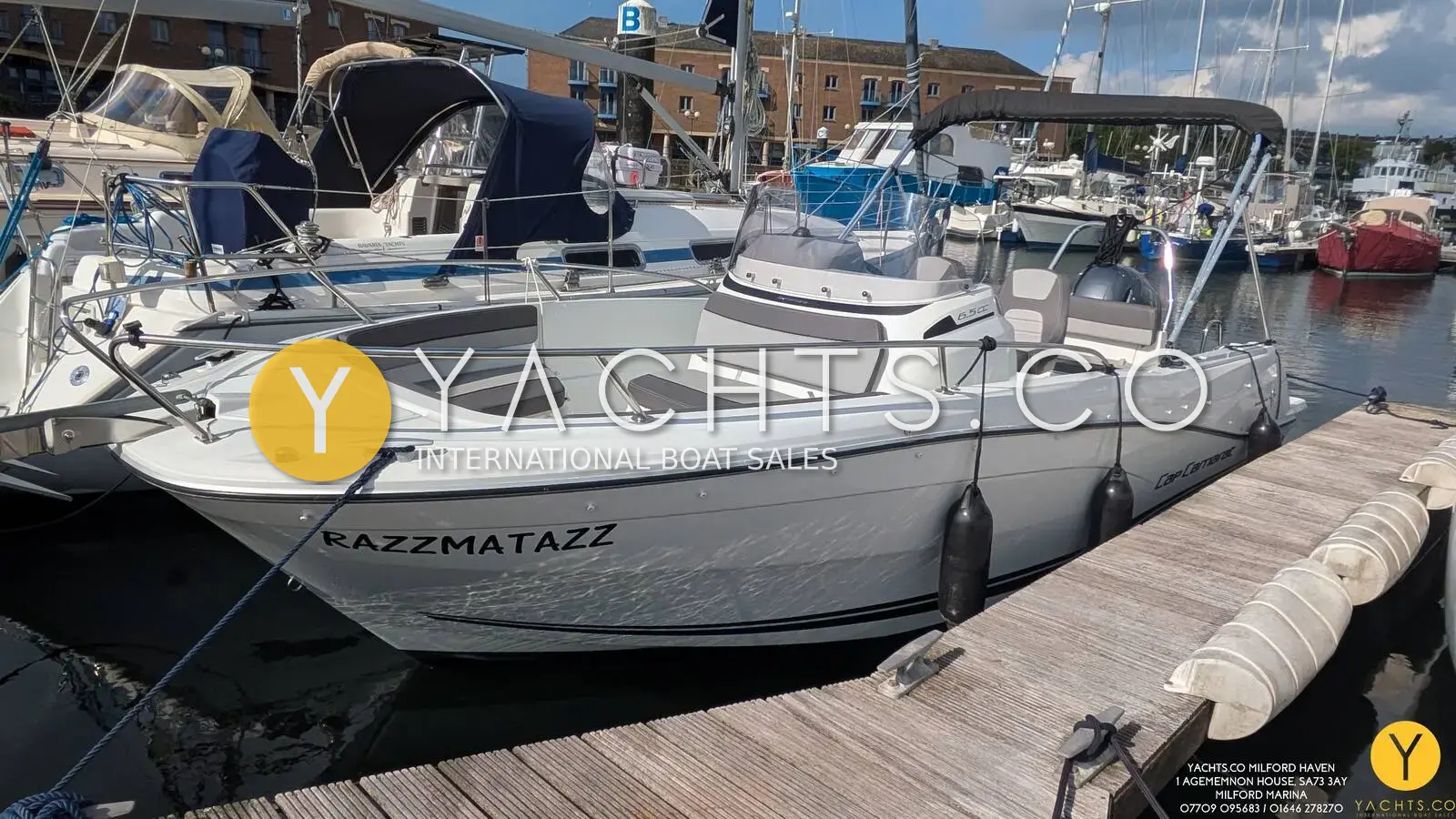 Jeanneau Cap Camarat 6.5 CC Serie 3: white centre console hull moored stern-to on a pontoon in a busy marina