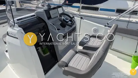 Jeanneau Cap Camarat 6.5 CC Serie 3: helm console with chartplotter and grey bolster seats beside open cuddy door