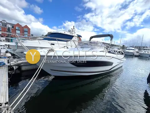 Jeanneau Cap Camarat 7.5 WA S2: starboard bow view moored on a marina pontoon with waterside buildings behind