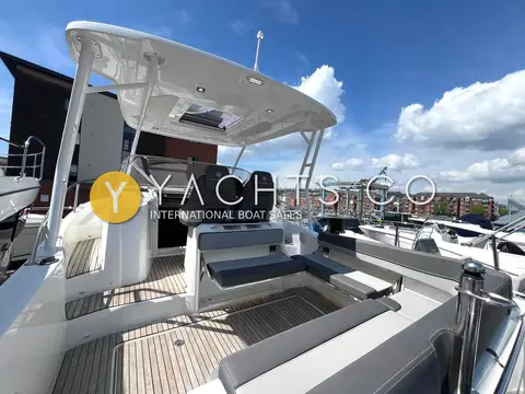 Jeanneau Cap Camarat 9.0 WA: cockpit from the stern showing teak sole, aft bench seating and helm seats under T-top
