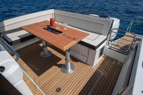 Jeanneau Cap Camarat 9.0 WA: aft cockpit with teak-style decking, wooden table on telescopic legs and wraparound seating