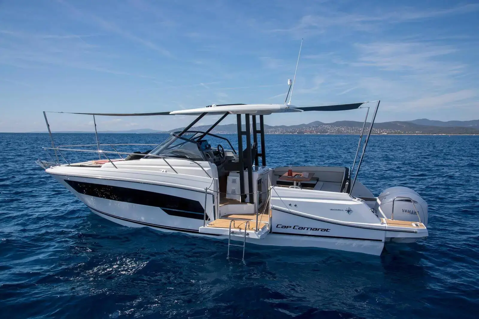 Jeanneau Cap Camarat 9.0 WA: white walkaround hull with dark hull windows and T-top, at rest on calm blue sea