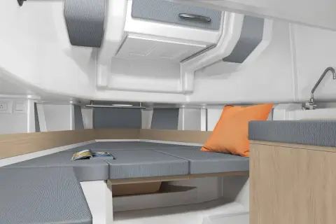 Jeanneau Cap Camarat 9.0 CC Serie 2: cabin interior with grey upholstered berth, light wood trim and orange cushion