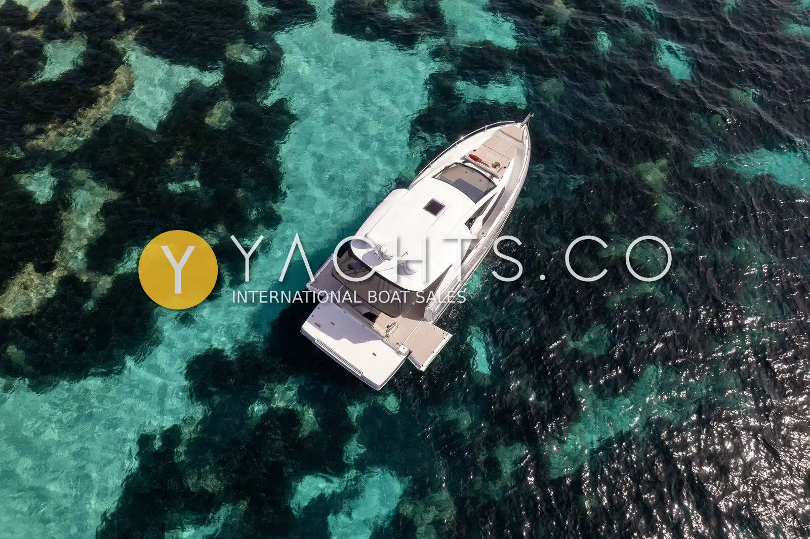 Jeanneau DB 37: aerial view of the boat at anchor over clear turquoise water and dark seabed