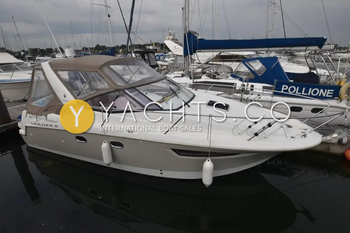 Jeanneau Leader 8: white hull with grey canopy fitted, moored stern-to in a marina beside other boats