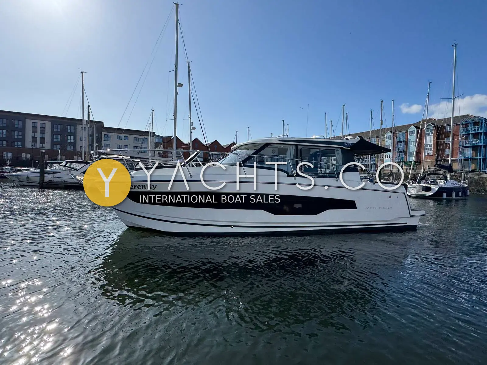 Jeanneau Merry Fisher 1095: starboard side of the white hull with dark window band, afloat in a Swansea marina