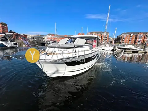 Jeanneau Merry Fisher 1095: bow view of the white hull on calm water, reflected in the marina