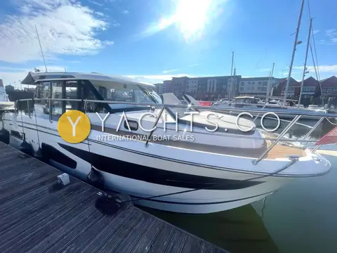 Jeanneau Merry Fisher 1095: port side alongside a wooden pontoon under bright sun, showing side deck access door