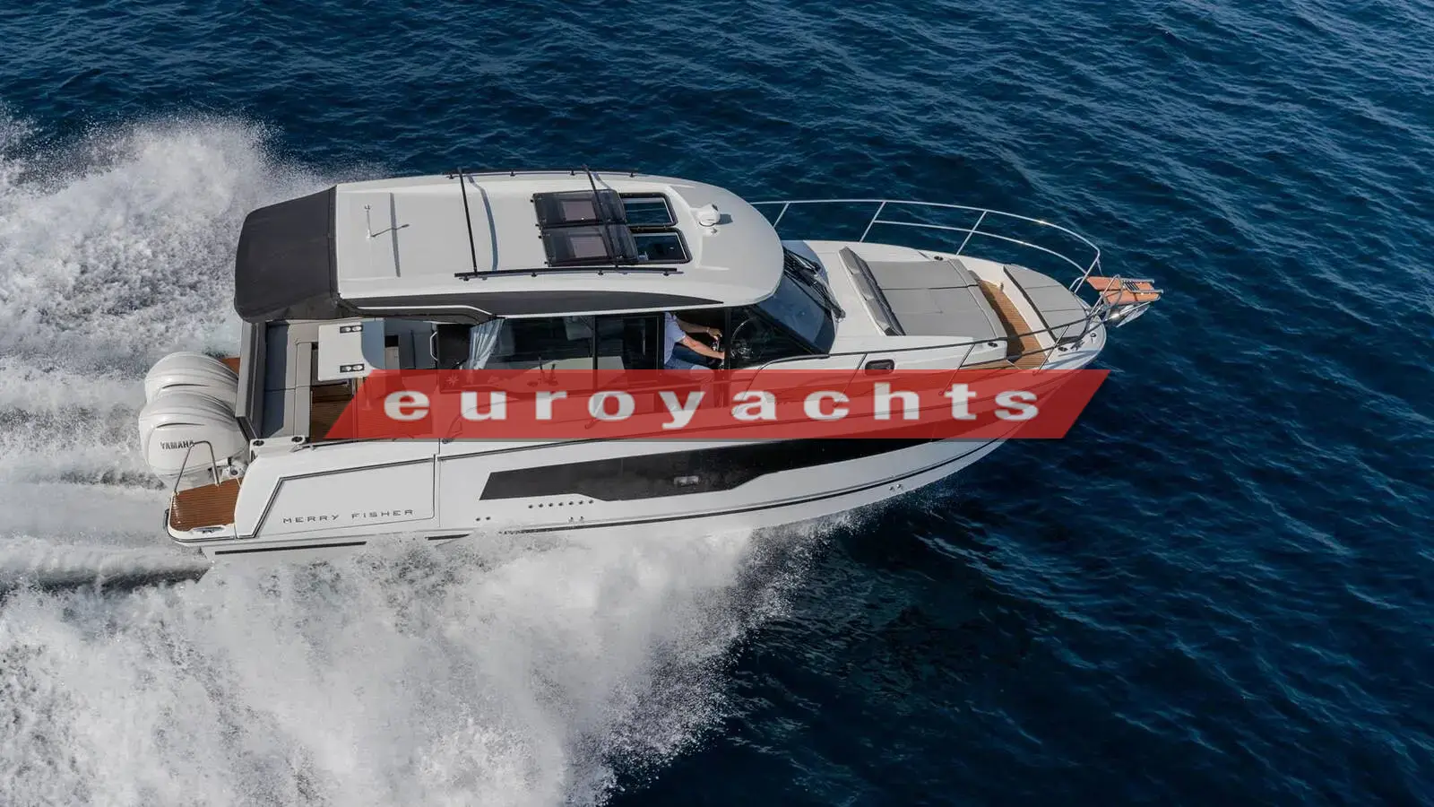 Jeanneau Merry Fisher 1095 Coupe Serie 2: aerial view of the hull under way, showing the open sunroof panels and twin white outboards