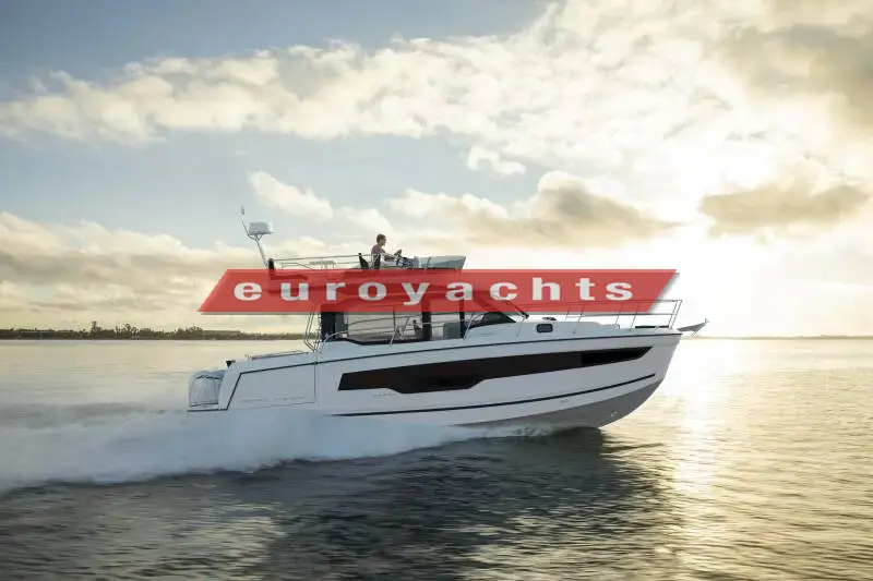 Jeanneau Merry Fisher 1095 Fly Serie 2: white flybridge motor boat under way at speed in calm water at sunset