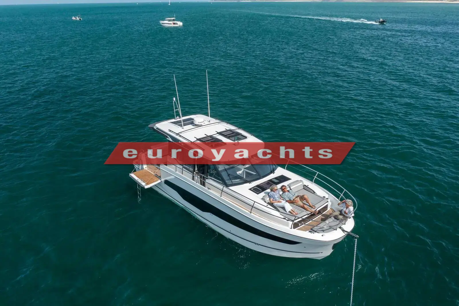 Jeanneau Merry Fisher 1295 Coupe S2: aerial view at anchor on green water, showing roof sunroofs, foredeck seating and aft swim platform