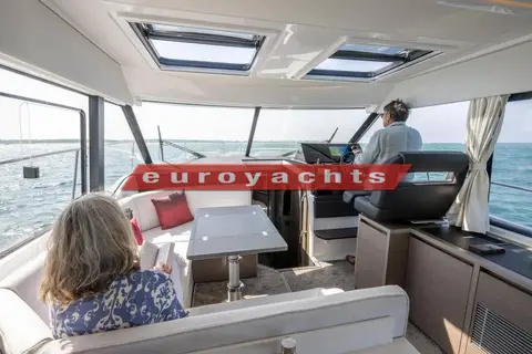 Jeanneau Merry Fisher 1295 Coupe S2: wheelhouse saloon with two opening sunroofs, table, light seating and helm station to starboard