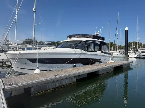 Jeanneau Merry Fisher 1295 Fly: bow quarter view alongside a pontoon in a marina on a sunny day