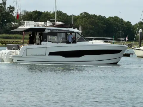Jeanneau Merry Fisher 1295 Fly: port side profile under way at slow speed along a wooded shoreline