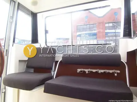 Jeanneau Merry Fisher 6 Marlin: wheelhouse seats with large sliding side window looking out over the marina