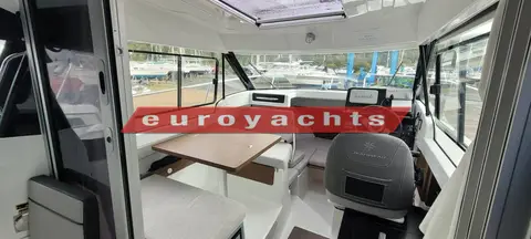 Jeanneau Merry Fisher 605: wheelhouse interior with dinette table to port, helm seat to starboard and open roof hatch