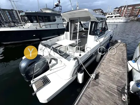 Jeanneau Merry Fisher 605 S2: stern quarter view moored alongside a pontoon, showing outboard, cockpit and wheelhouse