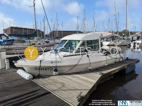 Jeanneau Merry Fisher 625: port side view alongside a wooden pontoon with blue sky and marina behind