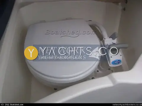 Jeanneau Merry Fisher 625 Legend: manual marine toilet with closed white lid and pump handle in moulded compartment