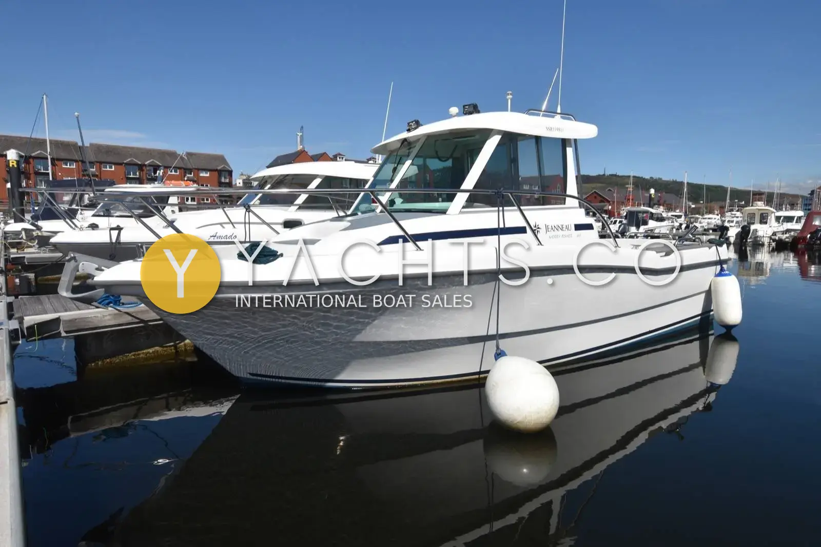 Jeanneau Merry Fisher 635: white hull and wheelhouse seen from the starboard bow, moored in a marina with fenders out