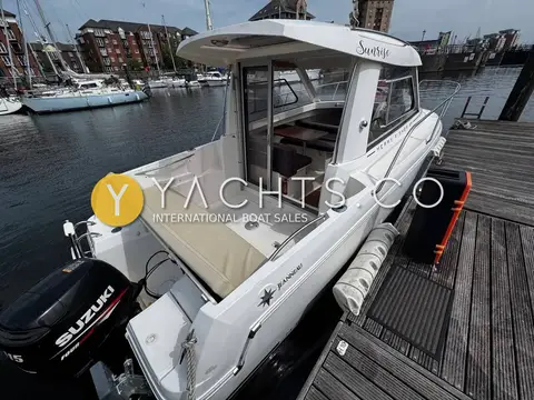 Jeanneau Merry Fisher 645: stern view of the cockpit with outboard engine, aft bench seat and wheelhouse door