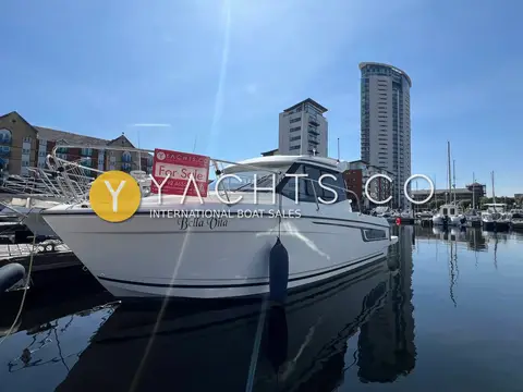Jeanneau Merry Fisher 695: port bow view afloat in Swansea marina with tall tower block behind