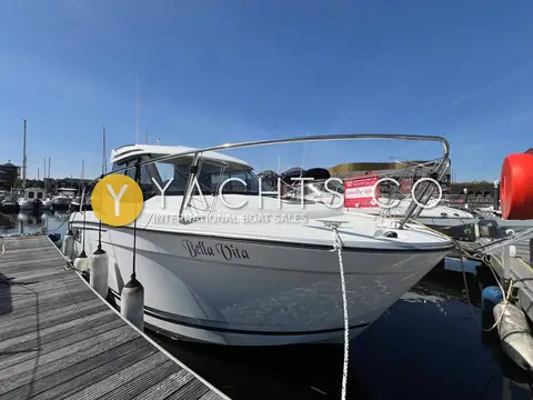 Jeanneau Merry Fisher 695: starboard bow afloat alongside a wooden pontoon, bow rails and fenders visible