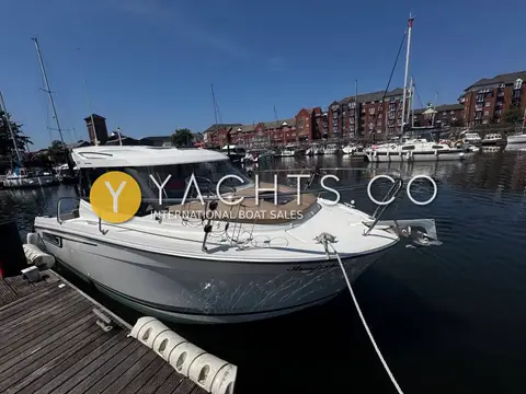 Jeanneau Merry Fisher 695: bow alongside a pontoon showing the foredeck sunpad, bow rails and mooring lines