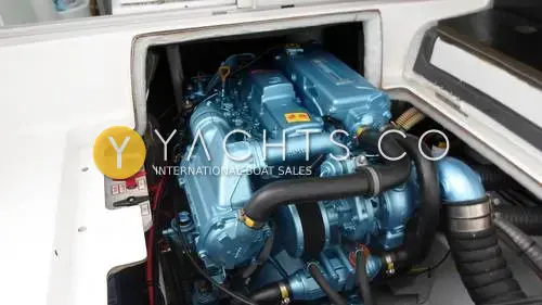 Jeanneau Merry Fisher 695: engine bay with hatch open showing the blue-painted diesel engine and hoses