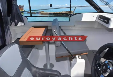 Jeanneau Merry Fisher 695: wheelhouse saloon with table folded and co-pilot bench backrest repositioned