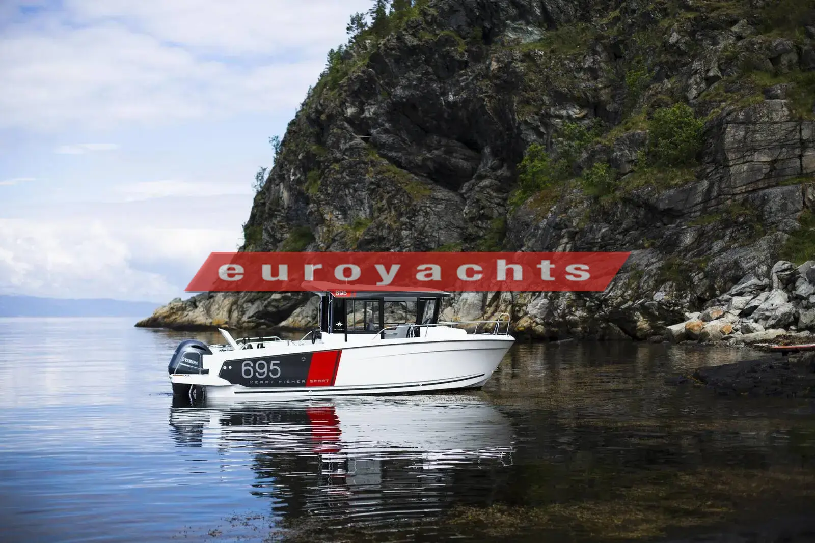 Jeanneau Merry Fisher 695 Sport: white hull with red stripe and wheelhouse at anchor beside a rocky, wooded shoreline