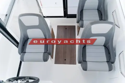 Jeanneau Merry Fisher 695 Sport: wheelhouse from above showing three grey bolster seats and wood-effect floor