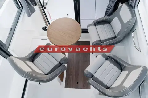 Jeanneau Merry Fisher 695 Sport: wheelhouse seats turned around a round wooden table, viewed from above