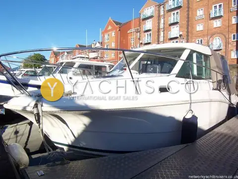 Jeanneau Merry Fisher 725: bow and starboard side with stainless guardrails, moored on a pontoon in front of brick flats