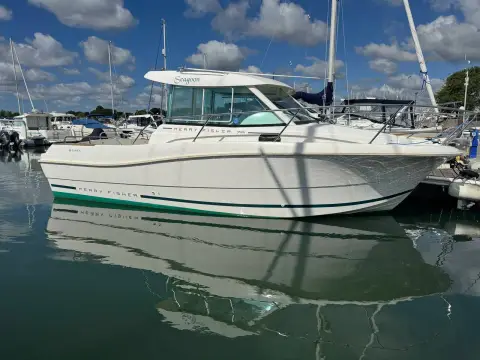 Jeanneau Merry Fisher 725: side profile of the white hull reflected in still marina water