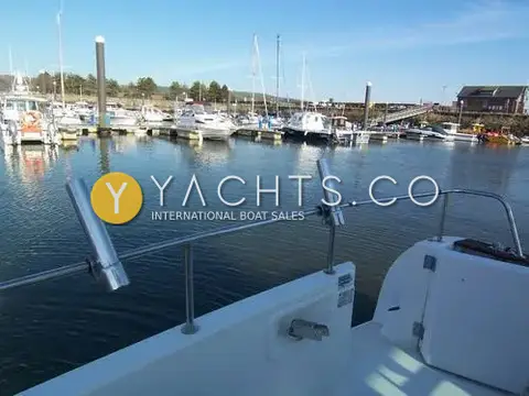 Jeanneau Merry Fisher 750 Reduced: cockpit rail with stainless rod holders, looking out over the marina