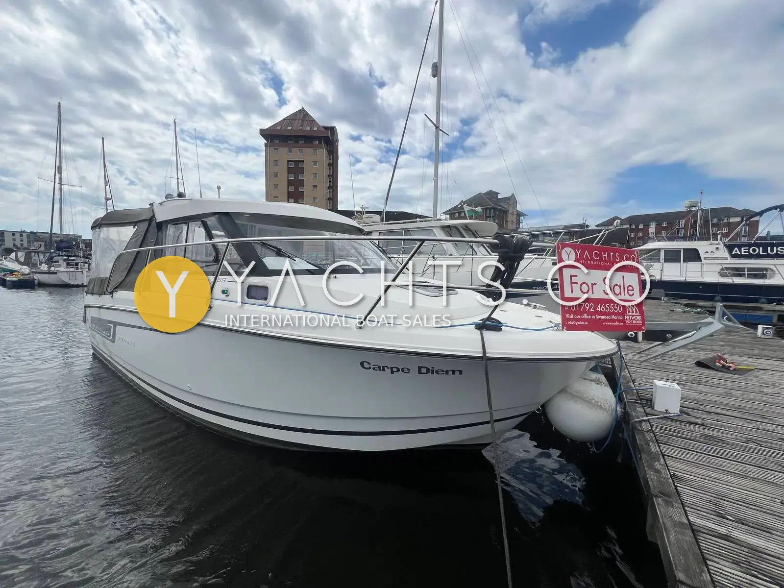 Jeanneau Merry Fisher 755: starboard bow view of the white hull moored on a marina pontoon with a For Sale sign