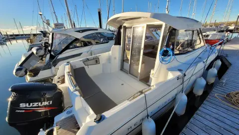 Jeanneau Merry Fisher 755: aft cockpit with open sliding door into the wheelhouse, Suzuki outboard on transom