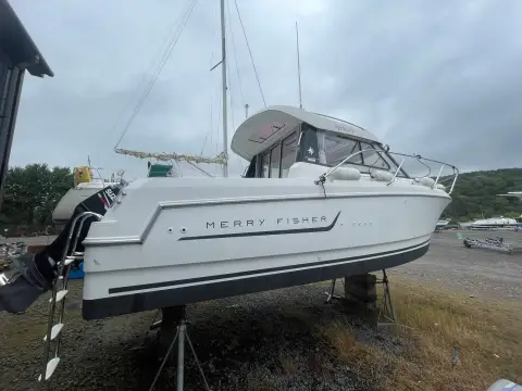 Jeanneau Merry Fisher 755: port side of the hull ashore on stands, showing Merry Fisher graphics and wheelhouse