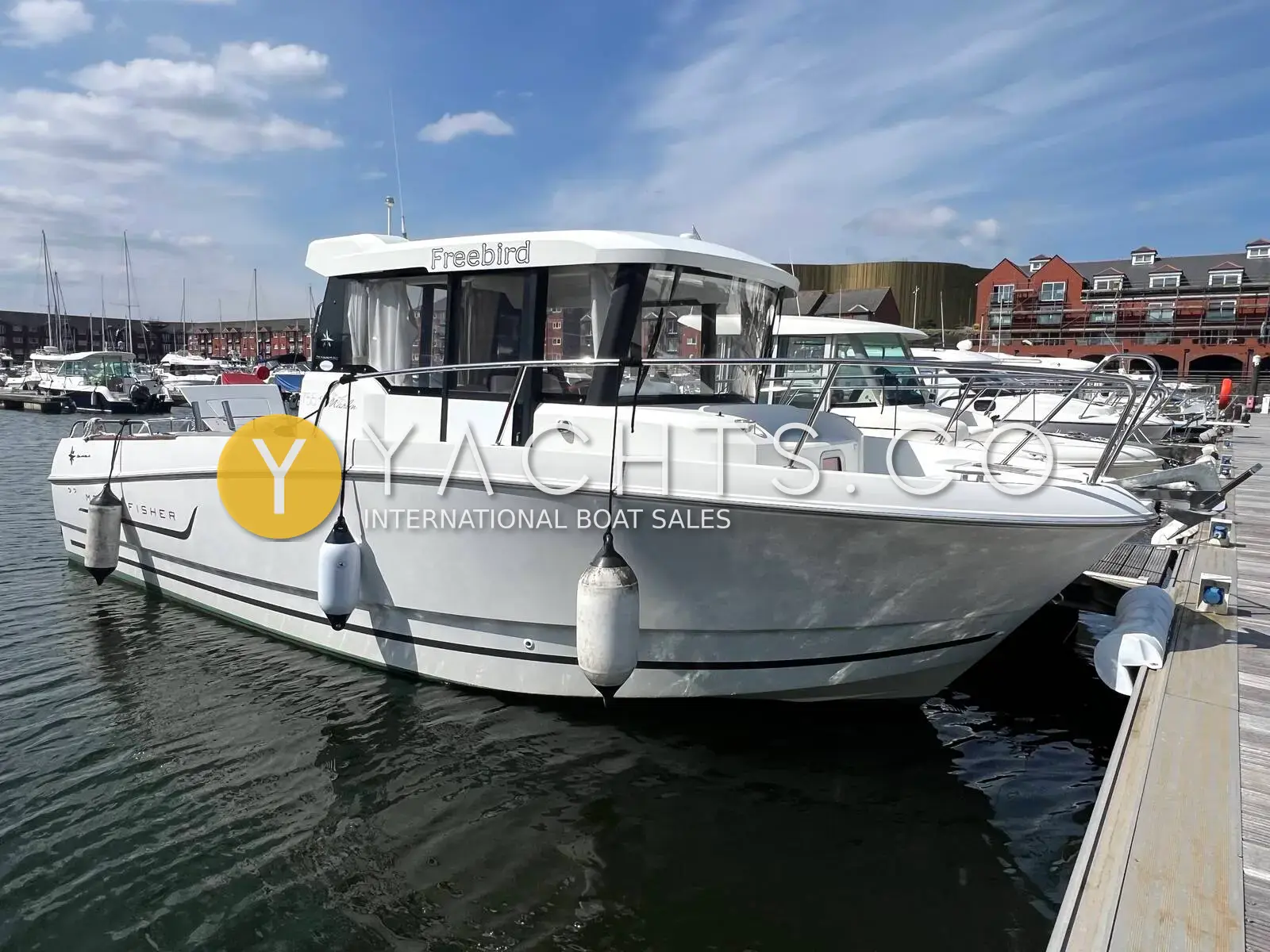Jeanneau Merry Fisher 755 Marlin: starboard side of the white hull and wheelhouse moored on a pontoon in a marina