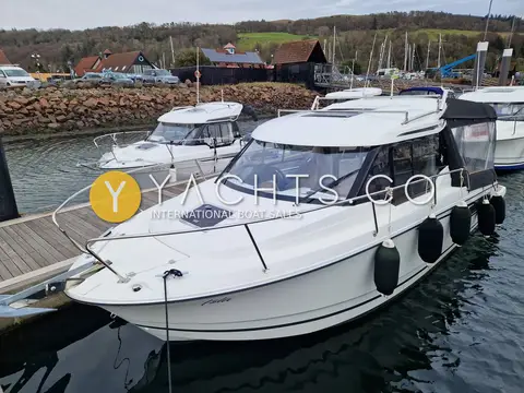 Jeanneau Merry Fisher 795: foredeck and cabin top with hatch and guardrails, moored beside a stone harbour wall